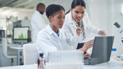 Shot of two young scientists using a laptop in a laboratory.