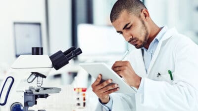 Shot of a scientist recording his findings on a digital tablet.