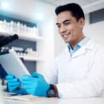 Happy, tablet or doctor in a laboratory with research results or positive feedback after medical data analysis. Smile, vaccine or healthcare worker reading or working on futuristic science innovation.