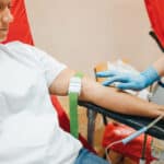Woman flexes muscles after donating blood.