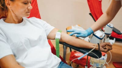 Woman flexes muscles after donating blood.