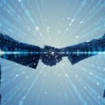 Two businessmen shake hands against a tech backdrop, indicating a company IPO or a merger between two technology stocks.