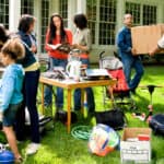 Seven people look for bargains to buy at a yard sale.