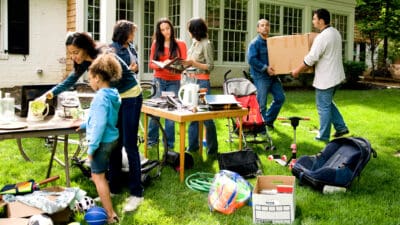 Seven people look for bargains to buy at a yard sale.