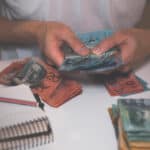 Person handling Australian dollar notes, symbolising dividends.
