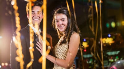 A young man and woman dressed in gold celebrate their courtship with a dance.