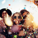 A group of young people celebrate and party outside.
