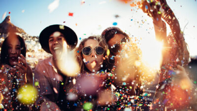 A group of young people celebrate and party outside.