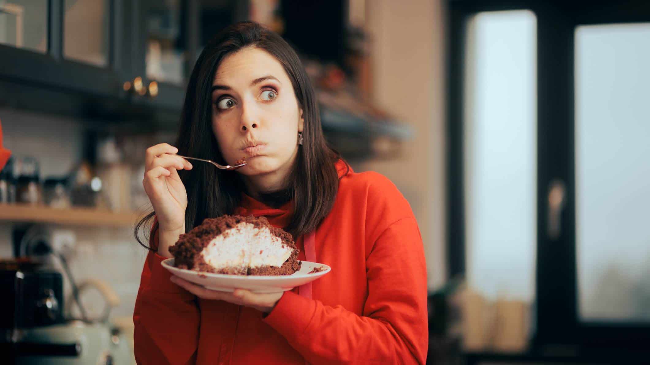 A rueful woman tucks into a sweet pie as she contemplates a decision with regret.
