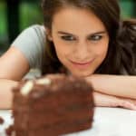 Woman staring at chocolate cake.