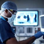 Surgeon looking at a monitor in an operating room.