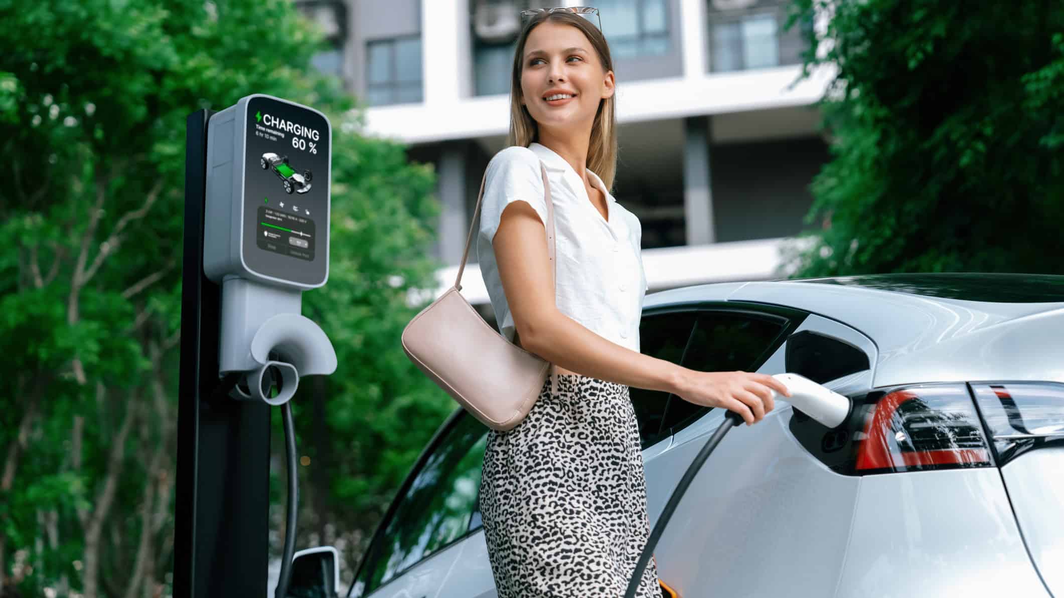Woman charging an electric vehicle.