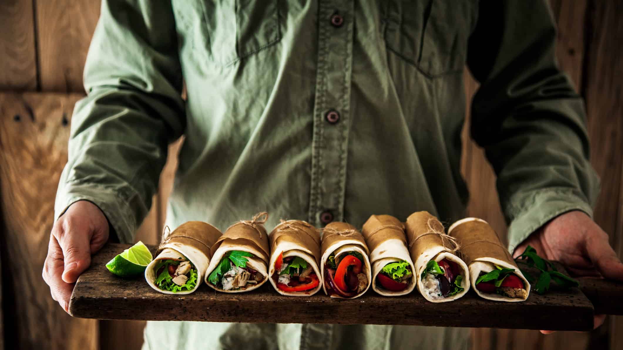 Man holding a tray of burritos, symbolising the Guzman share price.