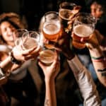 A group of friends cheering with beers.