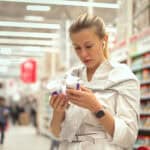 Woman checking bottle expiry dates.