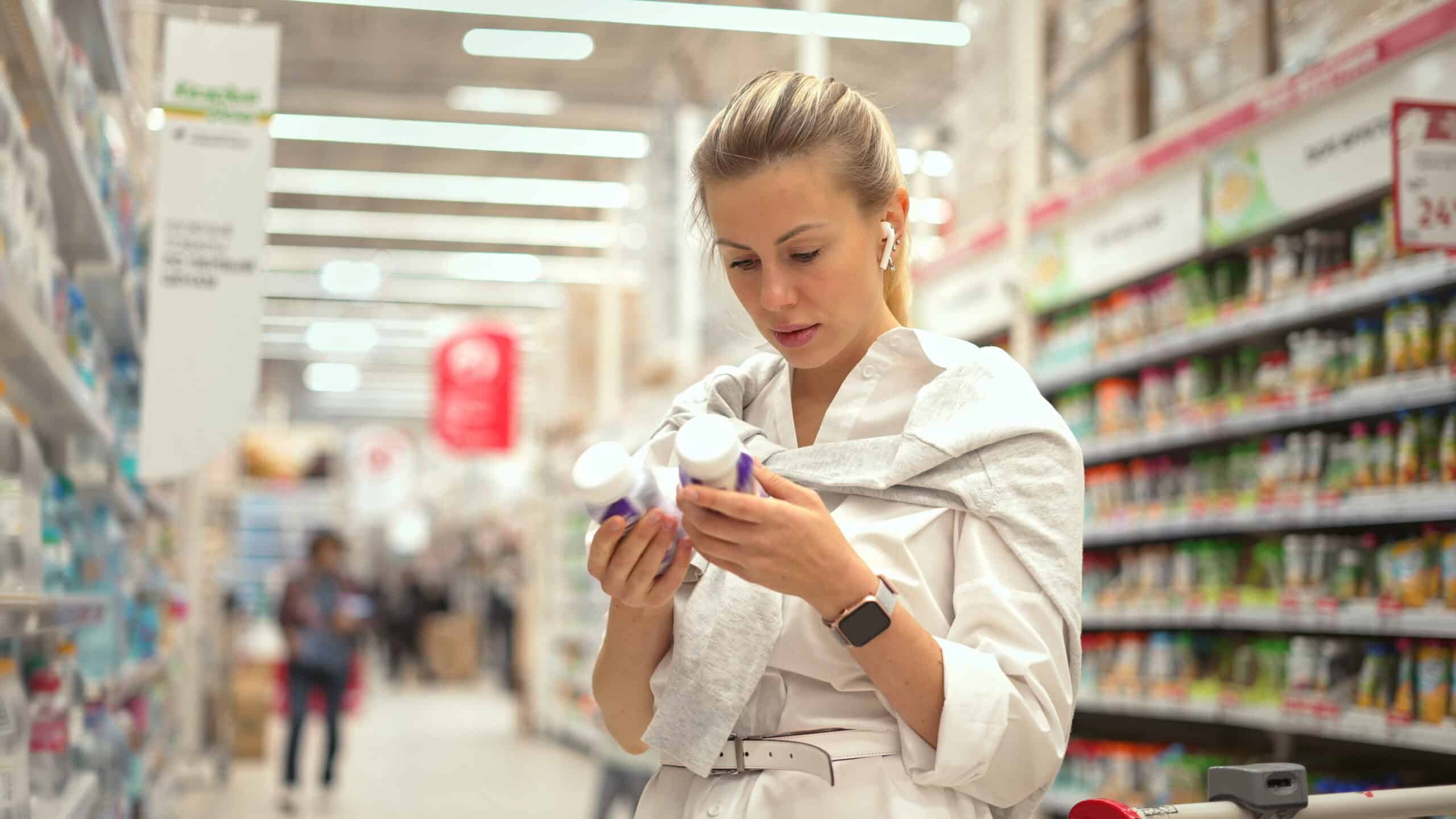 Woman checking bottle expiry dates.