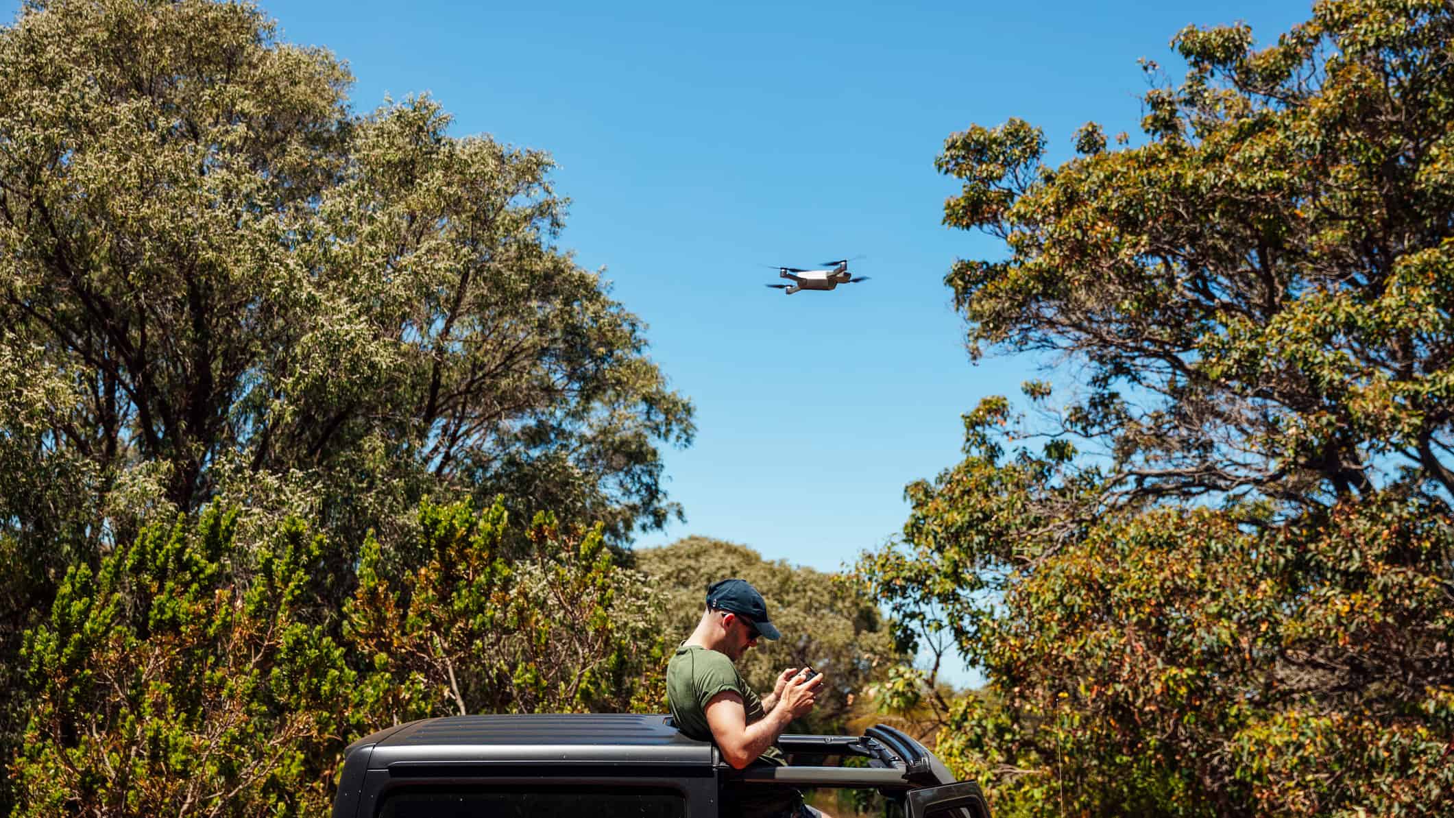 Man controlling a drone in the sky, symbolising DroneShield share price.