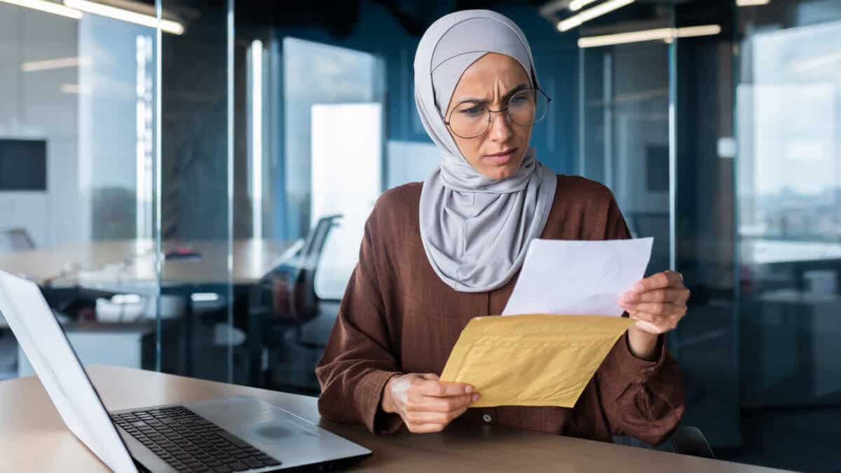 Upset business woman in hijab working inside office,.