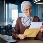 Upset business woman in hijab working inside office,.