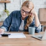 Worried woman calculating domestic bills.