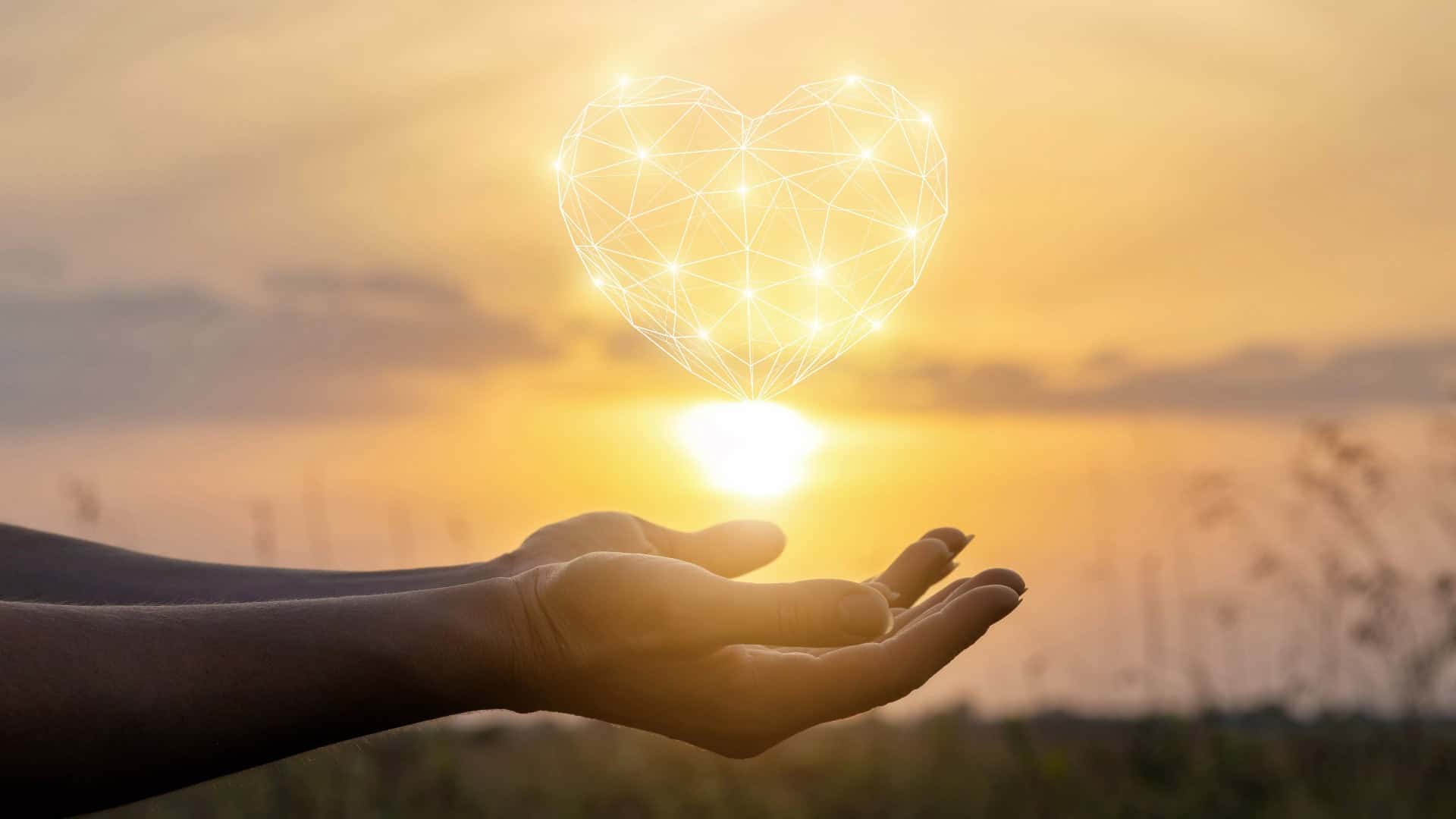 aHands pretending to hold the sun with a graphic love heart on top.