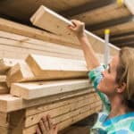 Woman handling a pile of hardware timber.