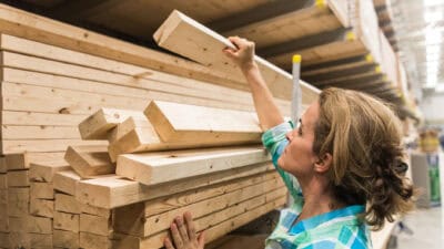 Woman handling a pile of hardware timber.