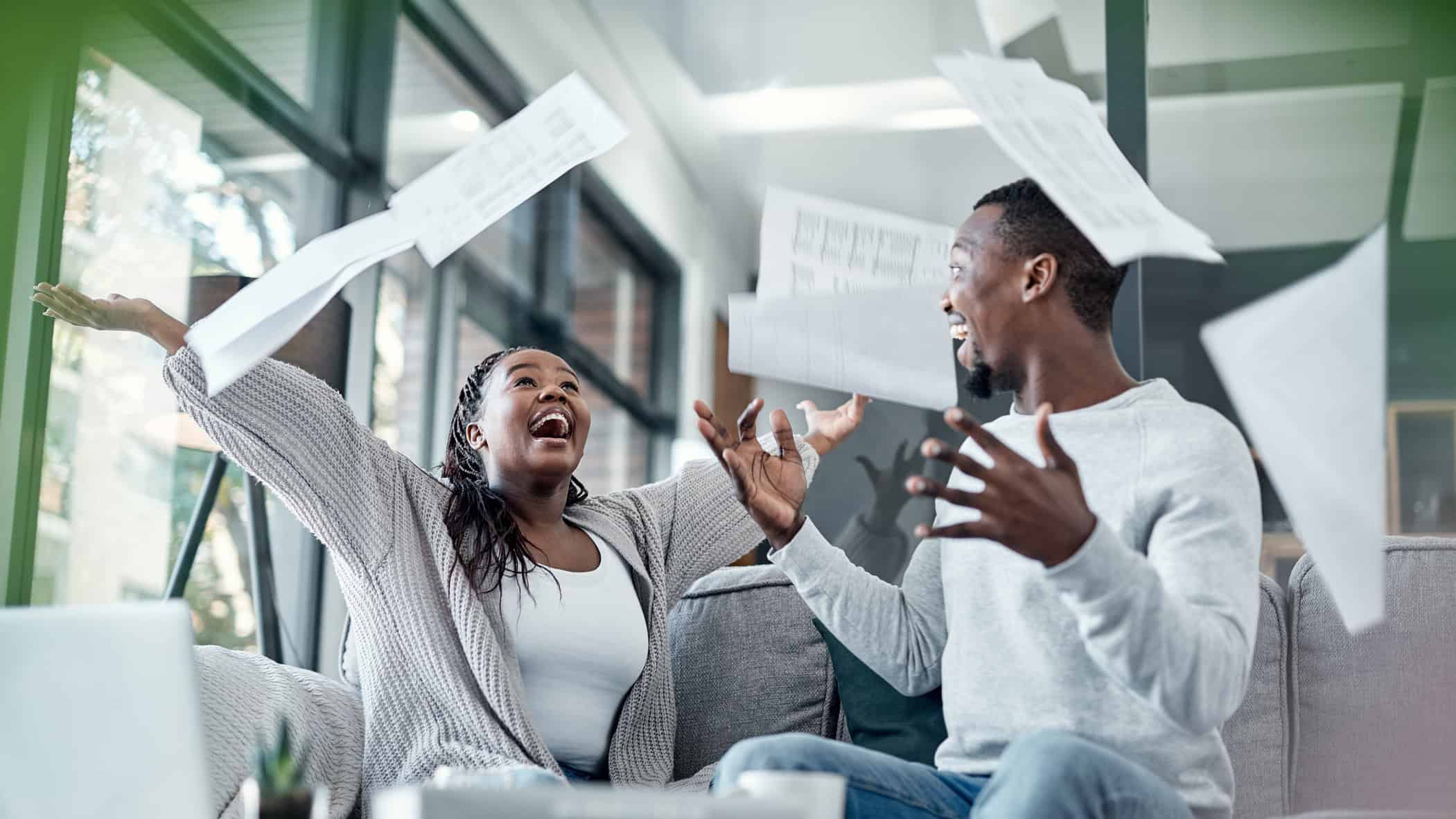 Two people toss papers in the air in joy.
