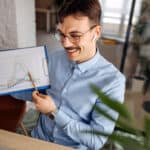 Smiling man points to graph comparing different companies.