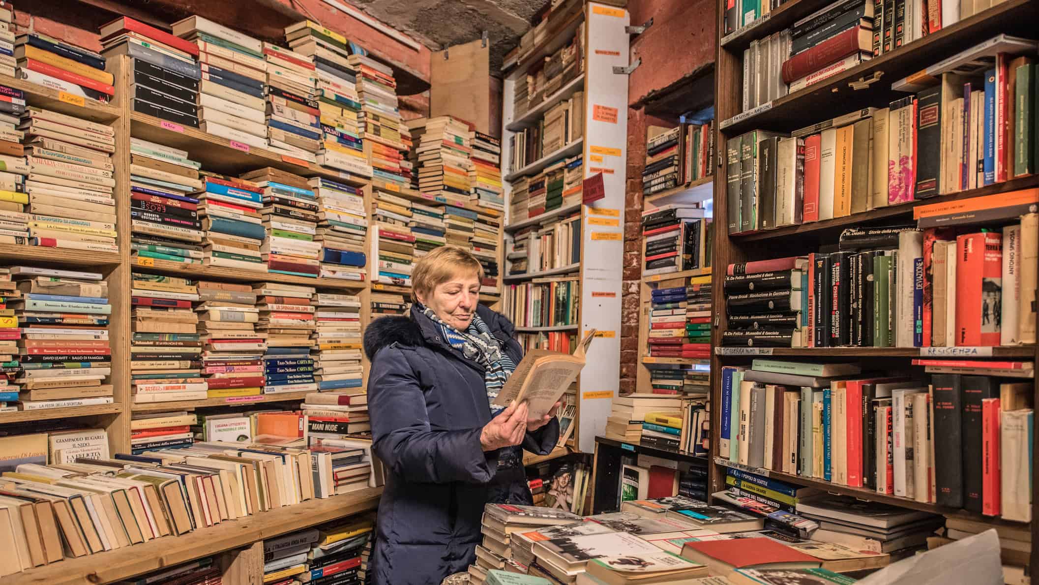 Woman going through a book in a book shop.