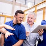 Four happy team members working together in a warehouse.