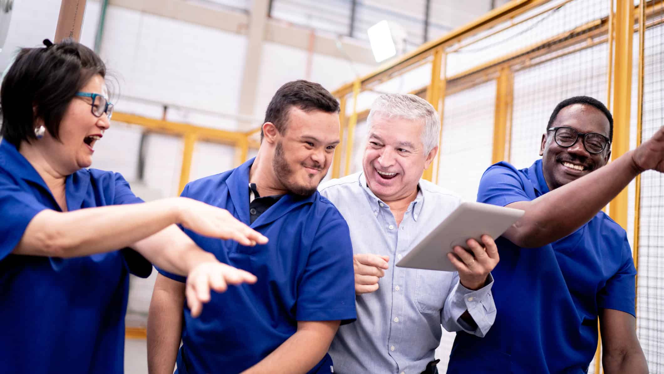 Four happy team members working together in a warehouse.