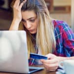 Young girl having problems with her credit card while shopping online.
