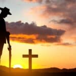 Silhouette of soldier paying tribute against the sunset - stock photo
