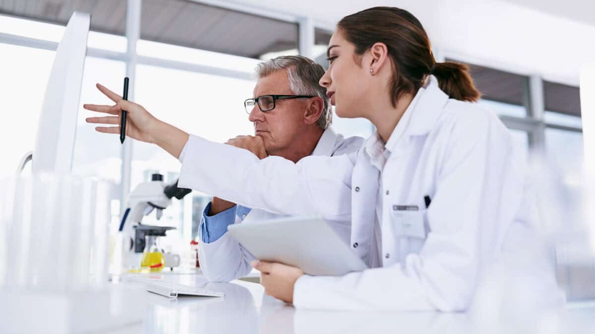 Male and female scientists analysing data on a computer.