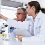 Male and female scientists analysing data on a computer.