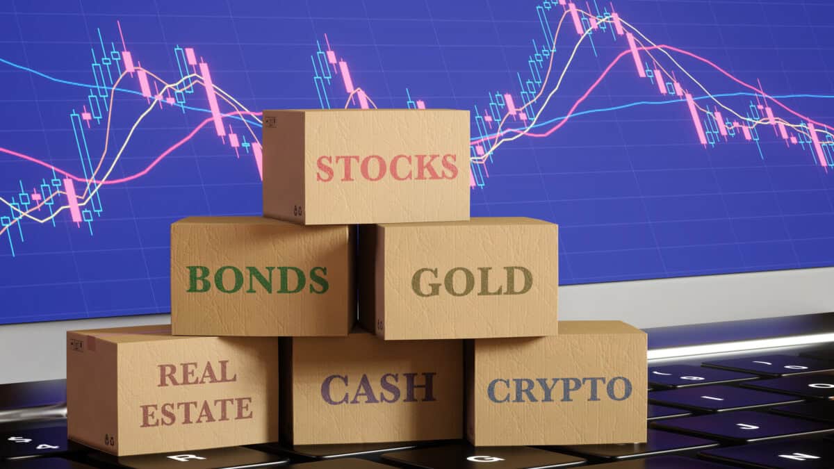 Boxes sitting on a laptop with different asset classes written, amidst a graph background.