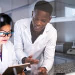 Two scientists looking at a tablet.