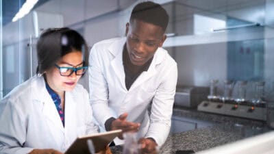 Two scientists looking at a tablet.