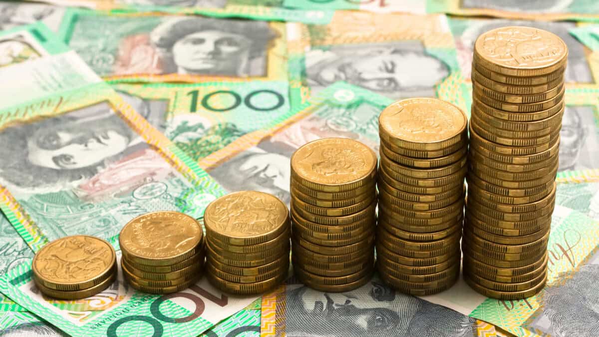 Piles of increasing coins on Australian $100 notes.