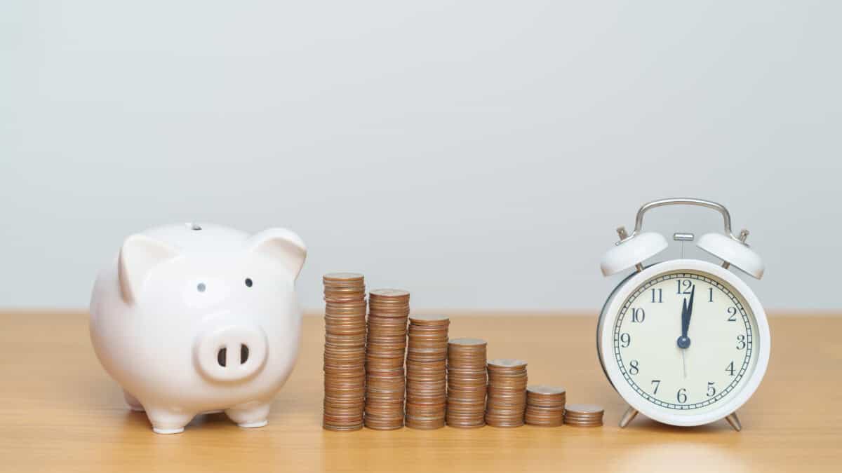 Coins in ascending order from left to right, with a piggy bank and clock on the sides.