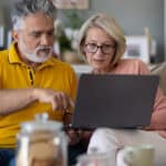 Senior couple looking at a laptop.