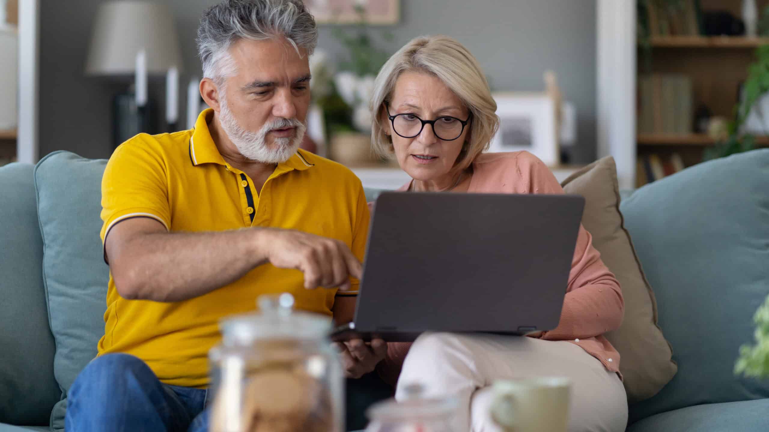 Senior couple looking at a laptop.