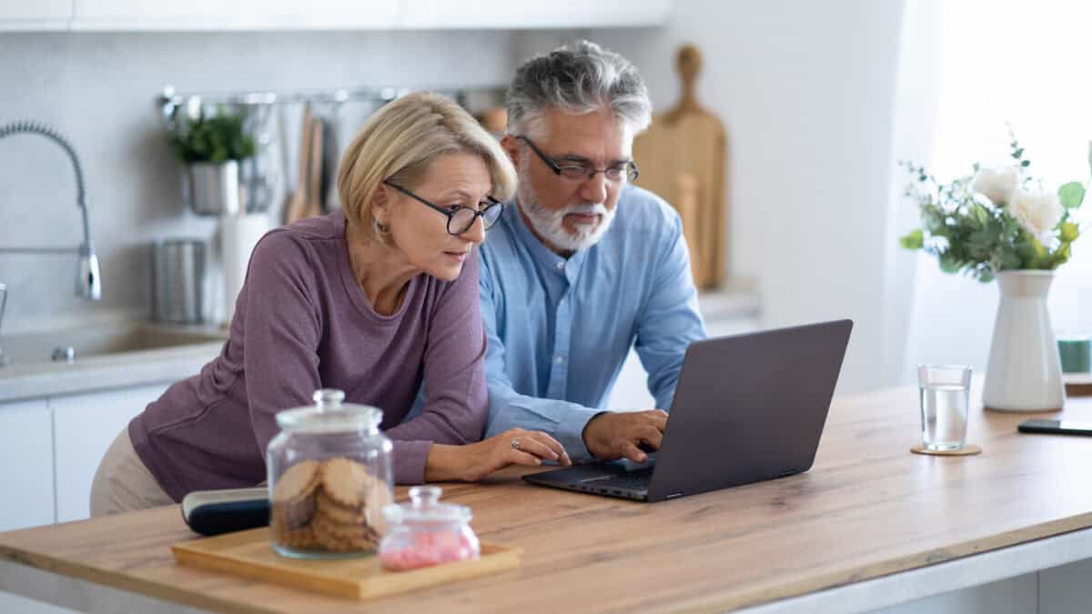 Couple on their laptop in their home kitchen.