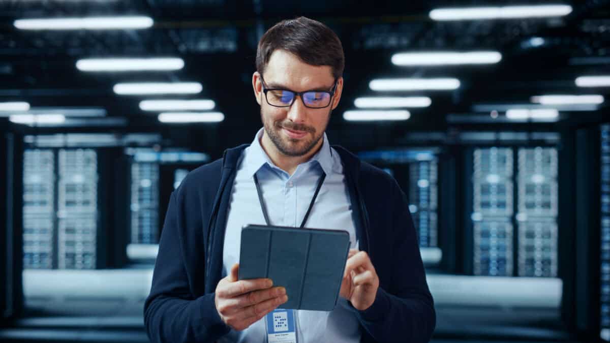 Man looking at his tablet in a data centre.
