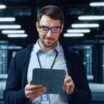 Man looking at his tablet in a data centre.