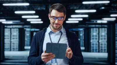 Man looking at his tablet in a data centre.