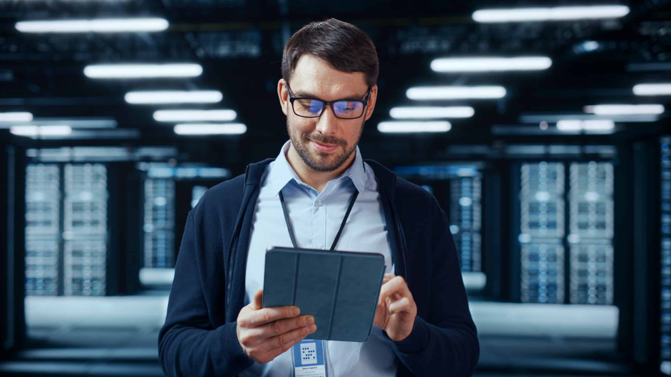 Man looking at his tablet in a data centre.