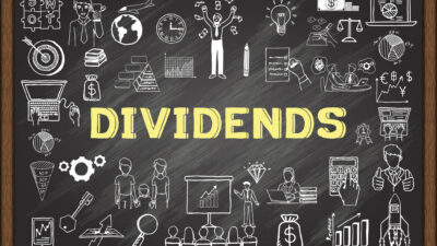 Dividends written in yellow on chalkboard, with finance-related diagrams.