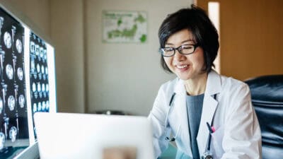 Happy doctor using her laptop.